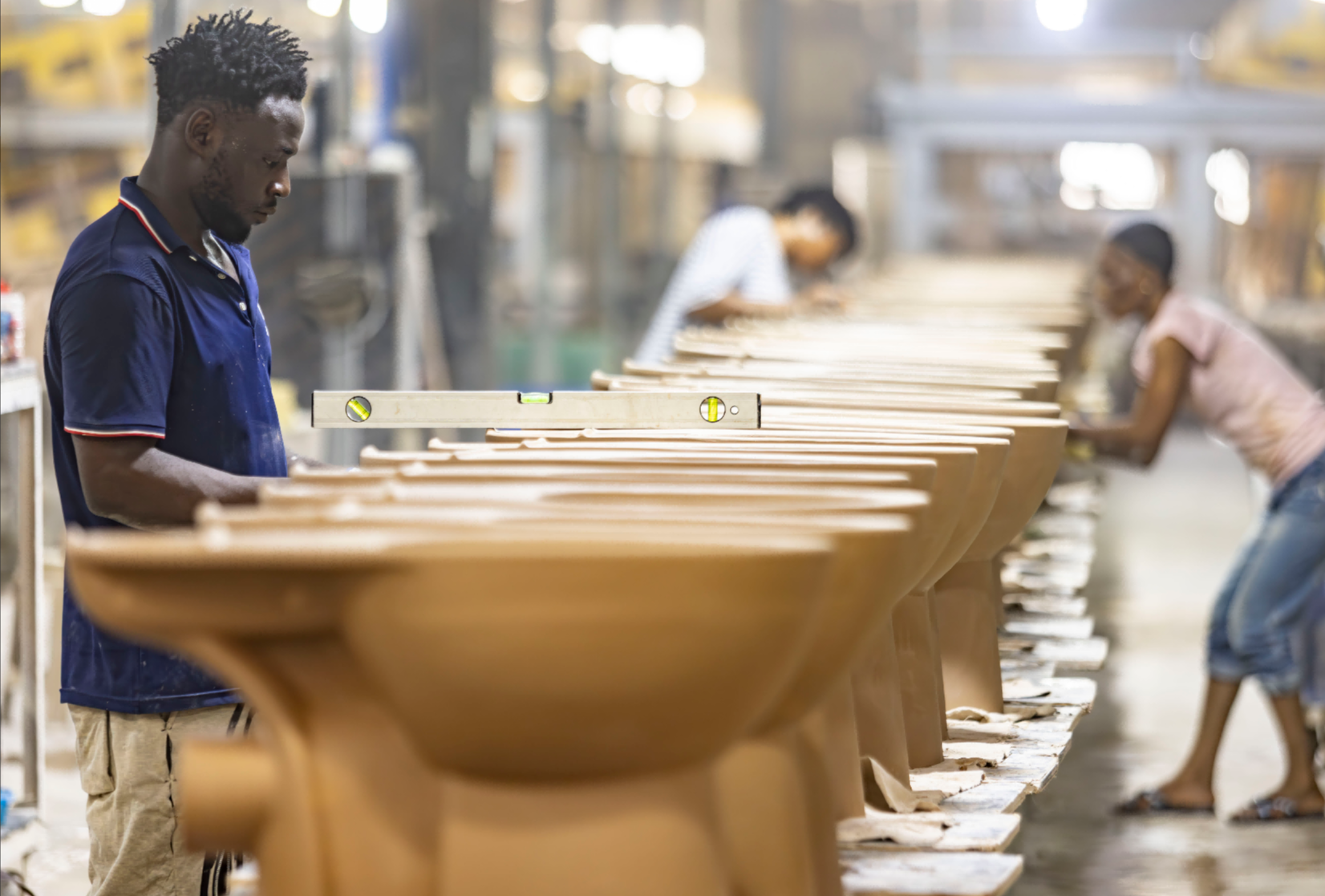 Worker inspecting sanitary ware moulds on a production line